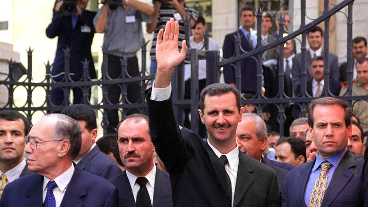 Le président Bachar al-Assad salue ses partisans, après avoir prêté serment, devant le Parlement à Damas, le 17 juillet 2000. (LOUAI BESHARA / AFP)