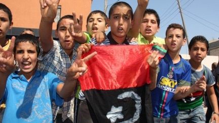 Des enfants fêtent la vicoire des rebelles, même si la bataille continue à Tripoli. (MAHMUD TURKIA / AFP)