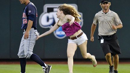 Et bim! Une spectatrice du match de baseball opposant la Caroline du Sud &agrave; l'Arizona se pr&eacute;cipite sur le terrain pour toucher le post&eacute;rieur d'un des joueurs, Omaha (Caroline du Sud), le 25 juin 2012. (ERIC FRANCIS / AP / SIPA)