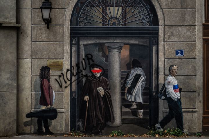 Le personnage de l'abbé Pierre barré de peinture rouge et pointé en tant que violeur sur la fameuse "Fresque des Lyonnais", à Lyon, le 30 septembre 2024. (JEFF PACHOUD / AFP)