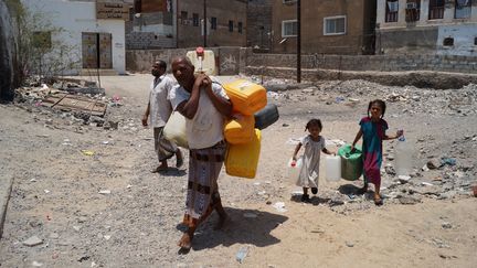 Des habitants d'Aden (Y&eacute;men) viennent remplir des bidons&nbsp;d'eau, le 5 avril 2015, dans une ville marqu&eacute;e par des combats et des coupures d'eau. (WAIL SHAIF THABET / ANADOLU AGENCY / AFP)