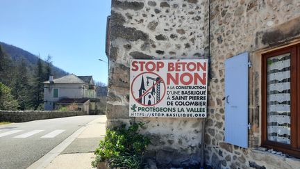 Dans le village, plusieurs affiches dénoncent depuis des années le projet de construction de l’immense église. (AGATHE MAHUET/FRANCEINFO)