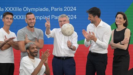 Le président du Comité international olympique (CIO), Thomas Bach, en compagnie de Tony Estanguet, le patron du Comité d'organisation de Paris 2024 et de la ministre des Sports, des Jeux olympiques et paralympiques, Amélie Oudéa-Castéra, le 26 juillet 2023 à Paris. (ALAIN JOCARD / AFP)