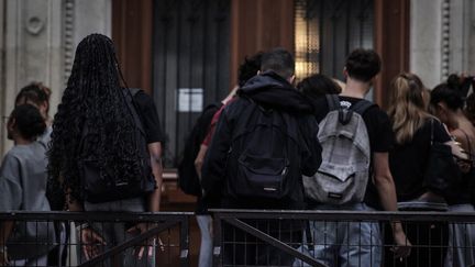 Des élèves devant un lycée, le 6 septembre 2024, à Paris. (THIBAUD MORITZ / AFP)