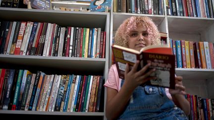 &nbsp;Lua Oliveira, 12 ans, dans sa bibliothèque de la&nbsp;favela Tabajaras favela à Rio de Janeiro au Brésil, le 10 mars 2020 (MAURO PIMENTEL / AFP)