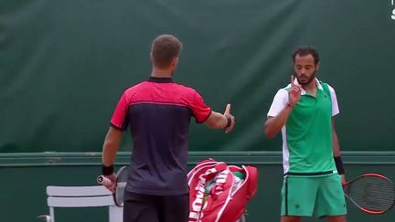 Le Français Laurent Lokoli, en vert, refuse la poignée de mains du Slovaque Martin Klizan à la fin de leur match, lors du tournoi de Roland-Garros, à Paris, le 30 mai 2017. (FRANCETV SPORT)