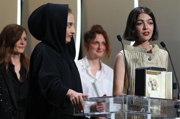 L'actrice iranienne et fille de Jafar Panahi, Solmaz Panahi (à droite) accepte le Prix du scénario pour "3 visages" à la place de son père, sous le regard de Chiara Mastroiani et d'Alice Rohrwacher, elle aussi lauréate de ce prix pour "Heureux comme Lazzaro". 
 (Valery HACHE / AFP)