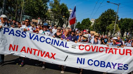 Banderole "Pass vaccinal = covictatur, ni antivax, ni cobayes" lors de la sixième manifestation anti-pass sanitaire, le 21 août à Lyon. (Illustration) (ROBERT DEYRAIL / GAMMA-RAPHO VIA GETTY IMAGES)