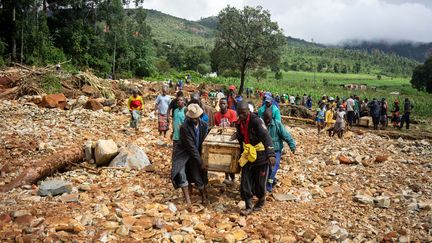 Des hommes portent le cercueil d'une victime du cyclone, à Ngangu, au Zimbabwe, le 18 mars 2019. (ZINYANGE AUNTONY / AFP)