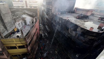 Plusieurs bâtiments d'un quartier historique de Dacca, la capitale du Bangladesh, ravagés par les flammes au lendemain d'un incendie qui a tué au moins 69 personnes, dans des immeubles d'habitation où se trouvaient des produits chimiques. (MUNIR UZ ZAMAN / AFP)