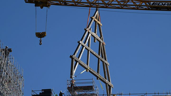 La première ferme de la charpente en bois de la cathédrale Notre-Dame de Paris est grutée, le 11 juillet 2023. (STEFANO RELLANDINI / AFP)