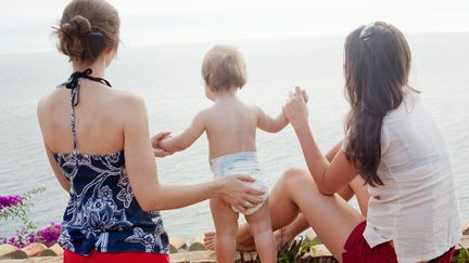 Deux femmes tiennent un b&eacute;b&eacute; en bord de mer. (CHEV WILKINSON / TAXI / GETTY)