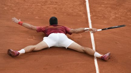 Au terme d'une glissade non contrôlée, le Serbe Novak Djokovic mord la poussière mais se qualifie pour la 15e année consécutive en quarts de finale à Roland-Garros. (CHRISTOPHE ENA / AP)