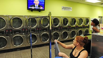 J-15 #TEAMOBAMA Des femmes regardent le 3&egrave;me d&eacute;bat pr&eacute;sidentiel &agrave; la t&eacute;l&eacute;vision depuis une laverie automatique &agrave; Chatsworth, pr&egrave;s de Los Angeles&nbsp;(Californie), le 22 octobre 2012. (ROBYN BECK / AFP)