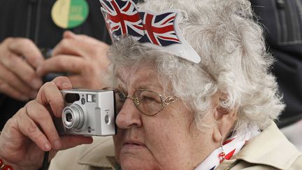 Une femme immortalise les c&eacute;l&eacute;brations du jubil&eacute; de diamant de la reine Elizabeth II sur la Tamise &agrave; LOndres (Royaume-Uni), le 3 juin 2012. (JUSTIN TALLIS / AFP)