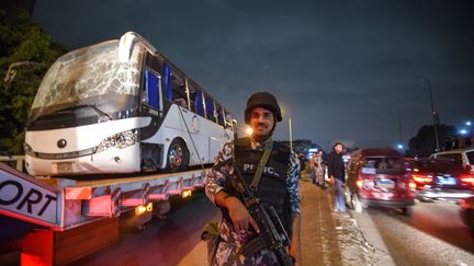 Un policier devant le bus attaqué près de Gizeh en Égypte, le 28 décembre.&nbsp; (MOHAMED EL-SHAHED / AFP)