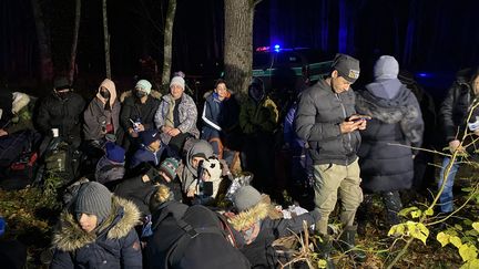 Des migrants irakiens attendent l'arrivée de l'officier des gardes-frontières polonais qui va décider de&nbsp;leur&nbsp;mise en détention provisoire en Pologne, dans les environs de Hajnowka, le 21 octobre 2021. (FABIEN MAGNENOU / FRANCEINFO)