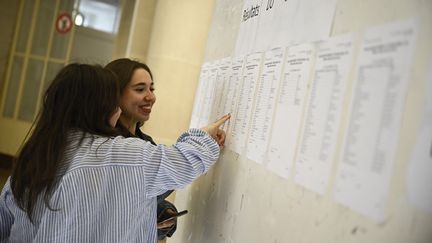 Des élèves regardent les listes des résultats au baccalauréat, le 8 juillet 2024 au lycée Claude-Bernard à Paris. (JULIEN DE ROSA / AFP)