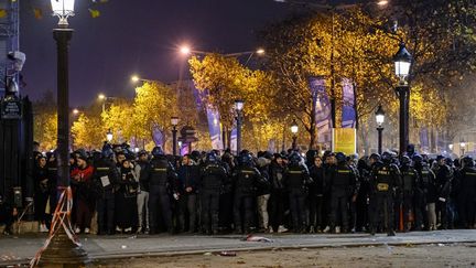 Des policiers en intervention sur les Champs-Elysées à Paris, le 10 décembre 2022, après les qualifications du Maroc et de la France en demi-finales de la Coupe du monde de football. (JULIEN MATTIA / ANADOLU AGENCY / AFP)