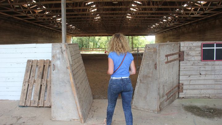 Marl&egrave;ne entre dans le man&egrave;ge d'&eacute;quitation du hameau, qui ne sera plus destin&eacute; &agrave; accueillir des chevaux, mais qui pourrait devenir une salle des f&ecirc;tes. (CLEMENT PARROT / FRANCETV INFO)