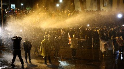 Des manifestants sont dispersés avec des canons à eau lors d'un rassemblement contre un projet de loi sur des "agents d'influence étrangère", le 8 mars 2023 à Tbilissi (Géorgie). (ZURAB TSERTSVADZE / AFP)