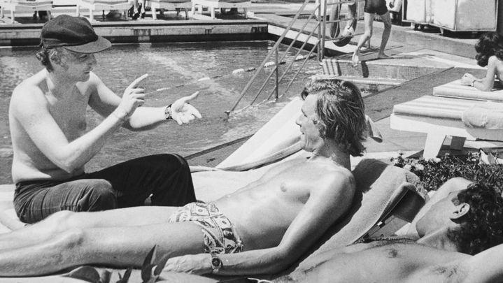 Le pilote Ferrari Niki Lauda (&agrave; gauche) discute avec son homologue de McLaren James Hunt, en pleine s&eacute;ance de bronzette, &agrave; Buenos Aires (Argentine), en janvier 1977. (KEYSTONE / ULSTON ARCHIVES / GETTY IMAGES)