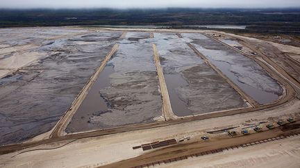 est le prix exorbitant de cette méthode d’extraction et la pollution qu’elle entraîne. Un baril provenant des sables bitumineux est dix fois plus énergivore qu’un baril conventionnel. Le volume d’eau indispensable pour pouvoir récupérer la matière première est huit fois plus élevé. Cette eau alors souillée doit être ensuite stockée dans des réservoirs spécifiques de décantation afin d’être décontaminée. Un baril de pétrole équivaut à un baril et demi de résidus toxiques, notamment les hydrocarbures aromatiques polycycliques dont seize sont classés comme d'importants polluants par l'Agence américaine de protection de l'Environnement.
 
 (Todd Korol  )