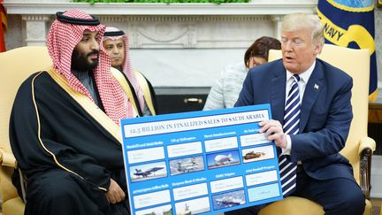 Donald Trump présente un tableau des ventes dans le secteur de la défense au prince héritier saoudien, Mohammed ben Salman, à la Maison Blanche (Etats-Unis), le 24 juillet 2019.&nbsp; (MANDEL NGAN / AFP)