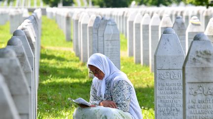 Une Bosniaque lit des prières parmi les tombes des victimes du massacre de&nbsp;Srebrenica perpétré en 1995 par les forces serbes (illustration). (ELVIS BARUKCIC / AFP)