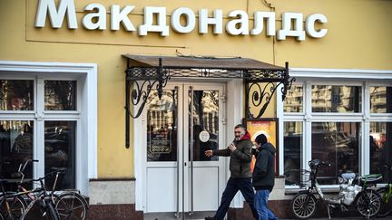 Des hommes entrant dans un McDonald's à Moscou, alors que la marque s'apprête à fermer ses enseignes dans le pays. (- / AFP)