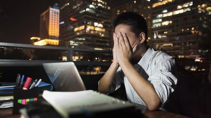 Photographie non dat&eacute;e d'un homme d'affaires chinois luttant contre le sommeil alors qu'il reste au bureau tard le soir.&nbsp; (BLEND IMAGE / JADE / GETTY IMAGES)