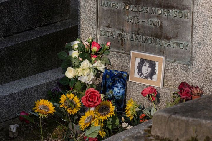 Des fleurs et des photos déposées sur la tombe de Jim Morrison au cimetière du Père Lachaise,à Paris, le 17 avril 2021. (SAM TARLING / GETTY IMAGES EUROPE)