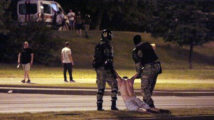 La police antiémeute biélorusse traîne au sol un manifestant&nbsp;opposé à la réélection pour un sixième mandat du président autoritaire Alexandre Loukachenko, le 9 août 2020 à Minsk. (SIARHEI LESKIEC / AFP)