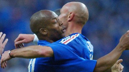 Sylvain Wiltord et Franck Lebœuf se congratulent après l'égalisation française face à la Belgique, le 18 mai 2002 au Stade de France. (REMY DE LA MAUVINIERE/AP/SIPA / AP)