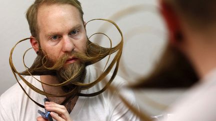 L'Am&eacute;ricain&nbsp;Justin Kellermeier parfait sa barbe avant de concourir au championnat du monde de barbe &agrave;&nbsp;Leinfelden-Echterdingen (Allemagne), le 2 novembre 2013. (MICHAELA REHLE / REUTERS)