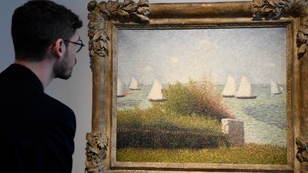 Un homme regarde le tableau "La rade de Grancamp" (1877) peint par Georges Seurat et qui fait partie de la collection Rockefeller. 
 (BERTRAND GUAY / AFP)