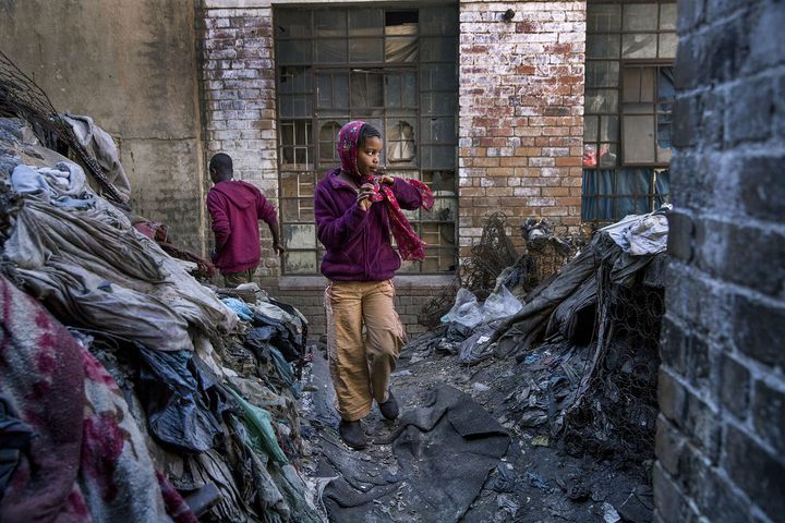 Entre deux immeubles squattés où vivent des migrants africains, Guguleto (8 ans) traverse la cour jonchée de détritus&nbsp;dans le centre-ville de Johannesburg (Afrique du Sud). (JONATHAN TORGOVNIK / THE VERBATIM AGENCY)