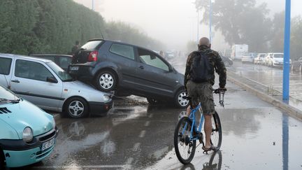 Un cycliste constate les d&eacute;g&acirc;ts caus&eacute;s par les orages, le 4 octobre 2015, &agrave;&nbsp;Mandelieu-la-Napoule (Alpes-Maritimes). (BORIS HORVAT / AFP)