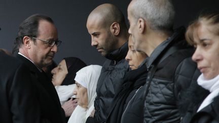 Fran&ccedil;ois Hollande salue la famille d'Ahmed Merabet, policier tu&eacute; le 7 janvier 2015, lors d'un hommage rendu &agrave; la pr&eacute;fecture de police de Paris, le 13 janvier 2015.&nbsp; (REUTERS)