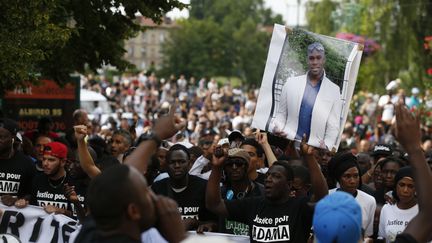 Des manifestants portent un portrait d'Adama Traoré, le 22 juillet 2016 à&nbsp;Beaumont-sur-Oise (Val-d'Oise). (THOMAS SAMSON / AFP)