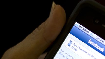 Une utilisatrice de Facebook sur smartphone en Malaisie, le 15 mai 2012. (SAEED KHAN / AFP)