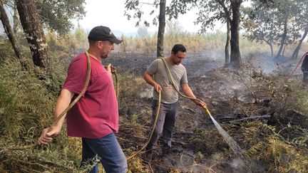 Dans un hameau, en lisière d'habitations, entre Louchats et Saint-Symphorien, Thomas Géral et son ami éteignent les fumées s'échappant encore du sol incandescent. (THOMAS GIRAUDEAU / RADIO FRANCE)