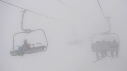 Des skieurs et snowboarders empruntent le t&eacute;l&eacute;ski dans un &eacute;pais brouillard lors des Jeux olympiques &agrave; Sotchi (Russie), le 17 f&eacute;vrier 2014. (FRANCK FIFE / AFP)