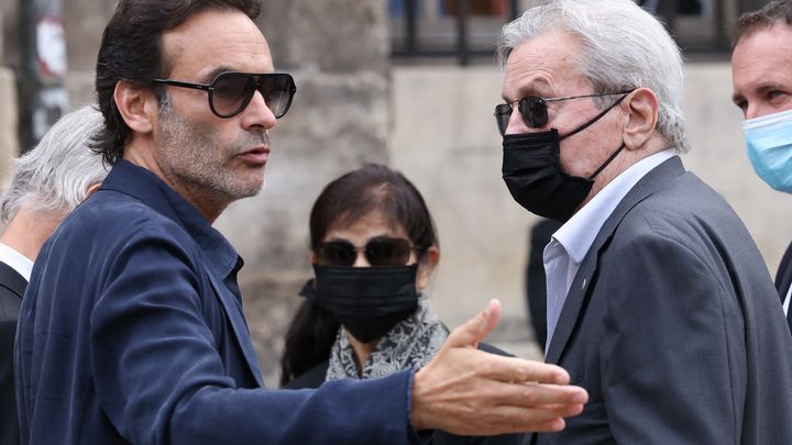 L'acteur Alain Delon, accompagné de son fils Anthony et de sa femme de compagnie, Hiromi Rollin, assiste aux obsèques de Jean-Paul Belmondo, le 10 septembre 2021, à Paris. (THOMAS COEX / AFP)