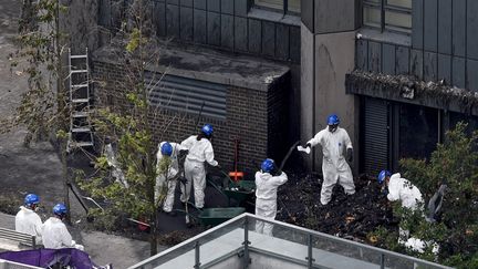 La police, ici le 30 juin 2017, continue de fouiller les décombres de la tour incendiée, alors que le bilan des victimes n'est pas définitif. (MAXPP)