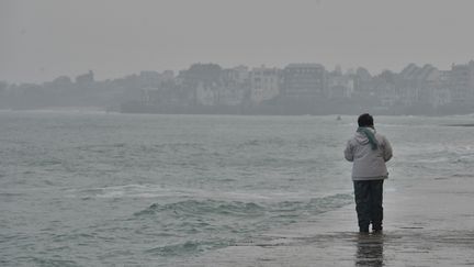 Un touriste observe la mar&eacute;e montante &agrave; Saint-Malo (Ille-et-Vilaine), le 21 mars 2015, lors de la "mar&eacute;e du si&egrave;cle".&nbsp; (KÉVIN NIGLAUT / CITIZENSIDE / AFP)