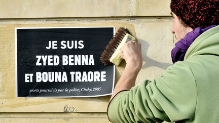 Un manifestant colle une affiche de soutien aux proches de Zyed et Bouna, le 18 mars 2015, lors d'un rassemblement contre les violences polici&egrave;res, &agrave; Rennes (Ille-et-Vilaine). (GEORGES GOBET / AFP)