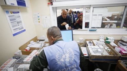 Un employé de l'agence onusienne pour les réfugiés palestiniens distribue des médicaments, à Gaza, le 21 janvier 2024. (ASHRAF AMRA / ANADOLU / AFP)