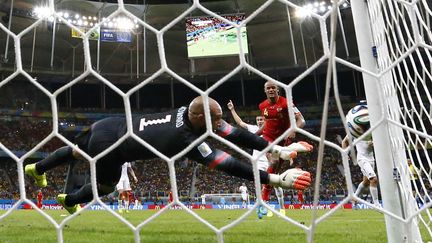 Le gardien am&eacute;ricain Tim Howard sauve son camp face &agrave; Vincent Kompany. La Belgique se qualifie&nbsp;(2-1 a.p.) malgr&eacute; ses 16 arr&ecirc;ts dans le match, nouveau record de la comp&eacute;tition. ( YVES HERMAN / REUTERS)