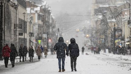 Des passants près de la place Kontraktova à Kiev (Ukraine), le 3 décembre 2022. (METIN AKTAS / ANADOLU AGENCY / AFP)